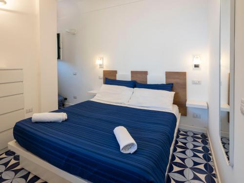 a bedroom with a large bed with blue sheets and white pillows at Villa Cliff House - Le Sea House in Atrani