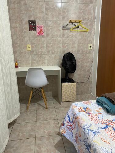 a bedroom with a desk and a chair and a bed at Pousada da Vânia in Vespasiano
