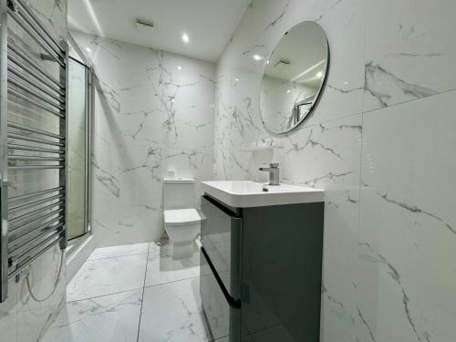 a white bathroom with a sink and a mirror at Seafarers Stays in Southampton