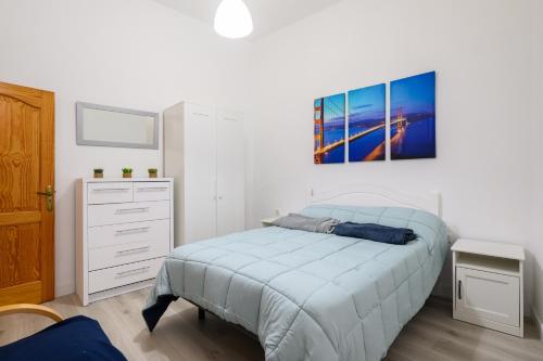 a bedroom with a bed and a painting on the wall at Casa JOY in Las Palmas de Gran Canaria