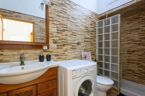 a bathroom with a washing machine and a sink at Casa JOY in Las Palmas de Gran Canaria