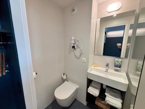 a bathroom with a toilet and a sink and a mirror at Sure Hotel by Best Western Annecy in Annecy