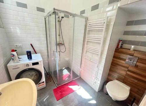 a bathroom with a shower and a washing machine at Leo Heart Rooms in Budapest