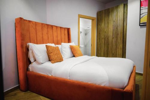 a bedroom with a large bed with orange pillows at Shortlet spaces in Lekki