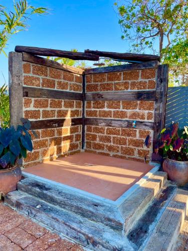 a brick wall with a wooden structure on it at MRK Resort & Massage in Lop Buri