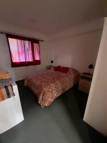 a bedroom with a bed and a window at Morada del sur in Ushuaia
