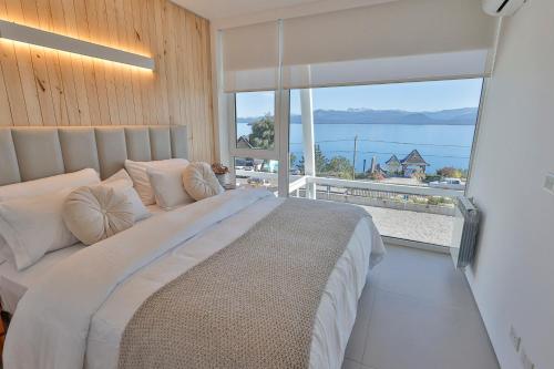 a bedroom with a large bed and a large window at Departamentos Luxe en Bariloche in San Carlos de Bariloche