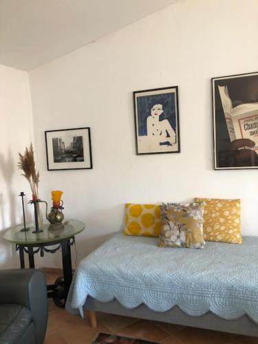 Cette chambre comprend un lit et une table avec des photos sur le mur. dans l'établissement Charmante maison dans village provençal, à Villedieu