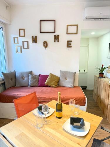 a living room with a couch and a table with a bottle of wine at Happy House with private garden in Rome