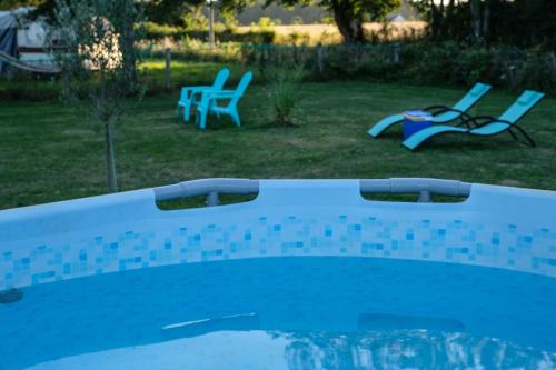 a swimming pool with two chairs and a table at La Fermette Henriette 3 sterren in Vicq-Exemplet