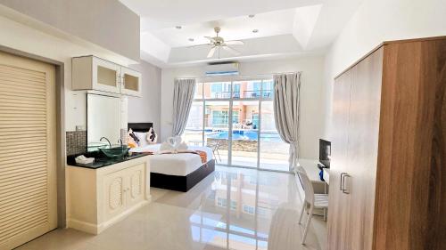 a bedroom with a bed and a large window at Sea Boss Homestay in Kata Beach