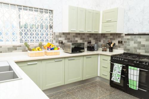 a kitchen with white cabinets and a black stove top oven at The Glenn House in Apenkwa