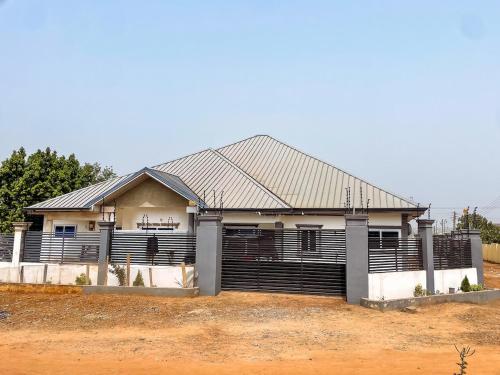 a house with a metal roof on a field at The Glenn House in Apenkwa