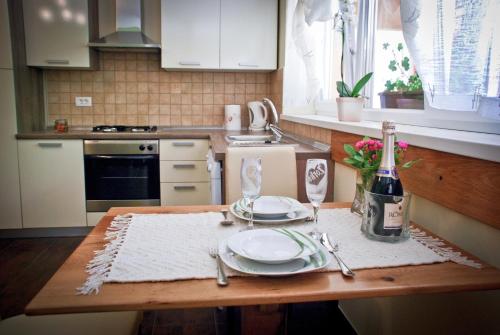 a kitchen with a table with plates and a bottle of wine at Garden House in Matulji