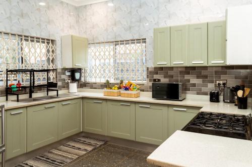 a kitchen with green cabinets and a counter top at The Glenn House in Apenkwa