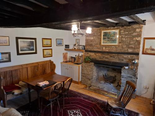 un soggiorno con tavolo e camino di Ty Gwyn Farmhouse a Brecon