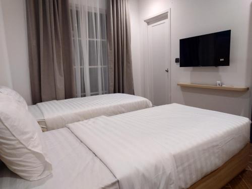a hotel room with two beds and a flat screen tv at Sun Bay Hotel Phu Quoc in Phu Quoc