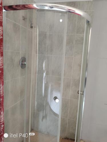 a shower with a glass door in a bathroom at Tenders Accommodation Rooms Mafikeng in Mahikeng