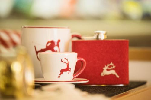 two coffee cups with deer on them sitting on a table at Arlberghaus in Zürs am Arlberg