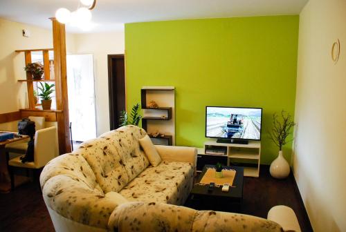 a living room with a couch and a flat screen tv at Garden House in Matulji