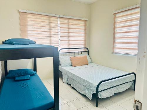 a room with two bunk beds and a bed and a window at The Alusiman Home - 4 bedroom home in Iloilo City
