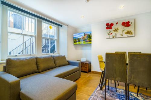 a living room with a couch and some windows at Angel x Kings Cross Hub in London
