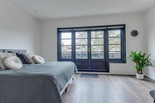 a bedroom with a bed and a large window at B&B aan de Gracht in Alkmaar