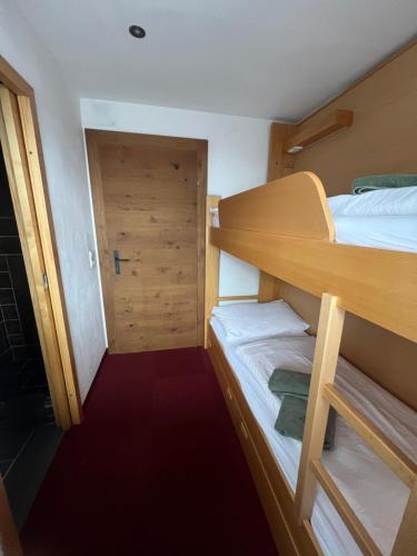 a small room with two bunk beds and a door at Hotel Forsthof in Sankt Johann im Pongau