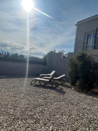 a pair of lounge chairs sitting on the side of a house at E casette in Oletta