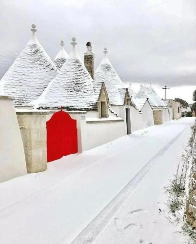 a row of houses with a red door in the snow at Dimora Cleó in Putignano
