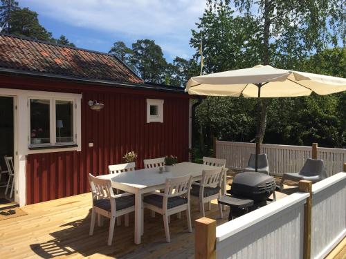 taras ze stołem i parasolem w obiekcie Cozy guesthouse by the sea w mieście Saltsjöbaden