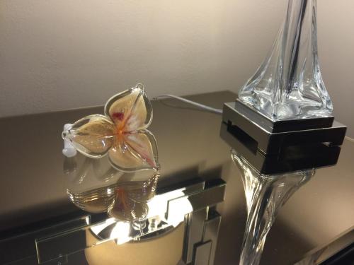 a glass vase with a flower in it on a table at Louisiana Cajun Mansion in Youngsville