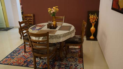 a dining room table and chairs with flowers on it at Portofino TreeHouse in Lavasa