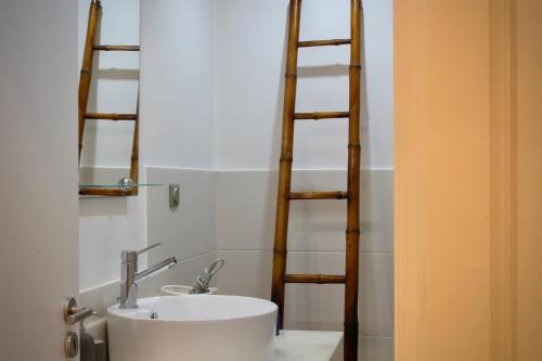 a bathroom with a sink and two wooden ladders at Like Home III - Apartamento com 2 quartos, ideal para famílias e amigos in Funchal