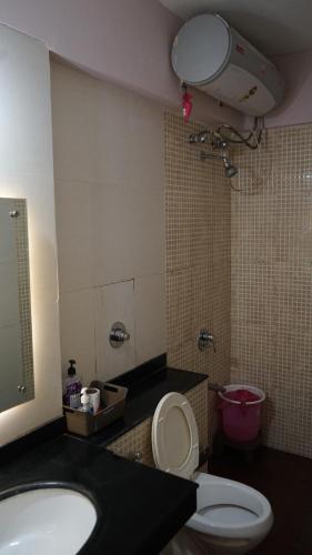 a bathroom with a toilet and a sink and a mirror at Portofino TreeHouse in Lavasa