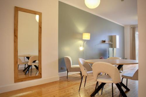 a dining room with a table and chairs and a mirror at Like Home III - Apartamento com 2 quartos, ideal para famílias e amigos in Funchal