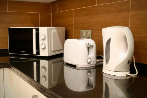 a kitchen with a coffee maker and a microwave at Like Home III - Apartamento com 2 quartos, ideal para famílias e amigos in Funchal