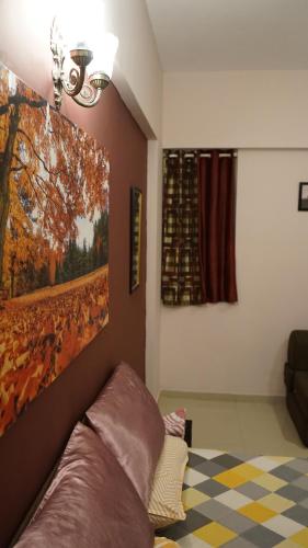 a living room with a large painting on the wall at Portofino TreeHouse in Lavasa