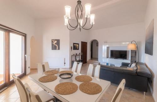 a dining room and living room with a table and chairs at Villa Eugenia in Košljun