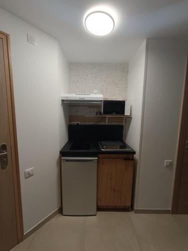 a small kitchen with a stove and a refrigerator at Hotel Le Beauregard in Divonne-les-Bains