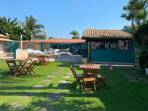 a group of tables and chairs in a yard at Pousada Riviera by Concavus in Caraguatatuba
