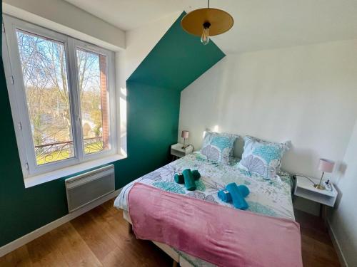 Un dormitorio con una cama y una pared verde. en KIKOR, belle vue sur le Loiret, en Saint-Pryvé-Saint-Mesmin