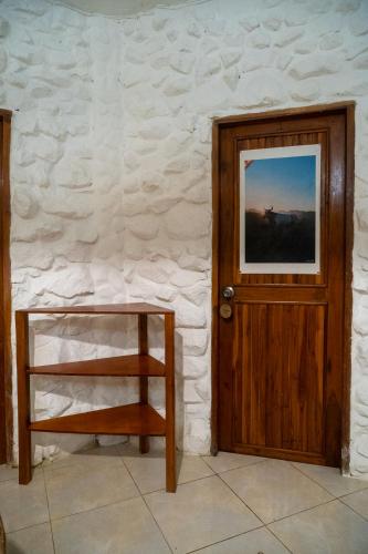 a wooden door and a chair next to a wall at Las Golondrinas Ayampe in Ayampe