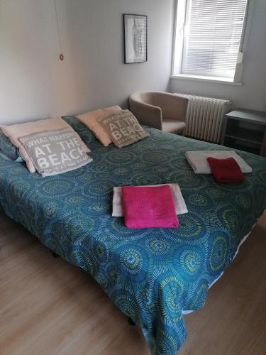 a bed with two pillows on it in a bedroom at Villa DM in De Haan