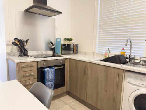 eine Küche mit Spüle und Geschirrspüler in der Unterkunft Spacious 5 Bedroom Gem Near Town Center, WiFi, Smart TVs, 2 Shower Rooms in Northampton