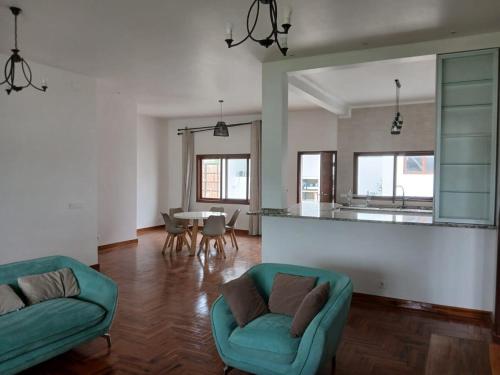 a living room with two green chairs and a table at Ntsudini 2 in Marracuene