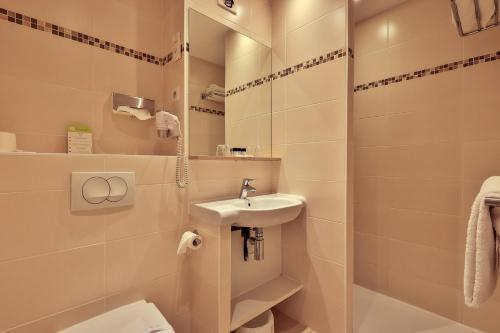 a bathroom with a sink and a toilet and a mirror at Le Petit Prince in Sainte-Maxime