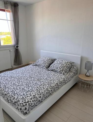 une chambre avec un lit avec une couette noire et blanche dans l'établissement appartement bayonne, à Bayonne