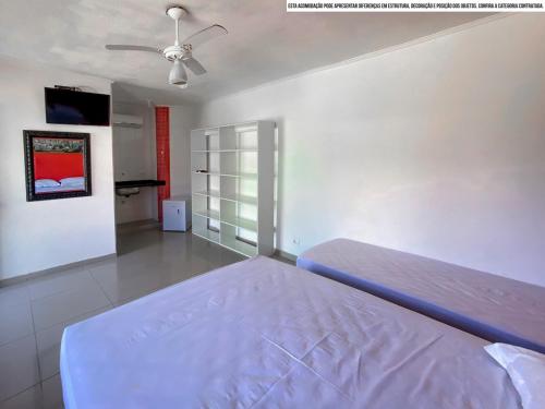 a bedroom with a bed and a ceiling fan at Pousada Riviera by Concavus in Caraguatatuba