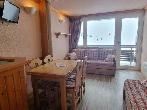 un salon avec une table et un canapé dans l'établissement Studio tout confort avec balcon, accès direct aux pistes - FR-1-181-2602, à Aime La Plagne